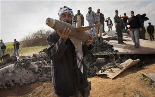 Libyans pose with the wreckage of a US  F15 fighter jet, after it crashed in an open field in the village of  Bu Mariem, east of Benghazi, eastern Libya, Tuesday, March 22, 2011, with both crew ejecting safely. The U.S. Africa Command said both crew members were safe after what was believed to be a mechanical failure of the Air Force F-15. The aircraft, based out of Royal Air Force Lakenheath, England, was flying out of Italy's Aviano Air Base in support of Operation Odyssey Dawn.(AP Photo/Anja Niedringhaus)