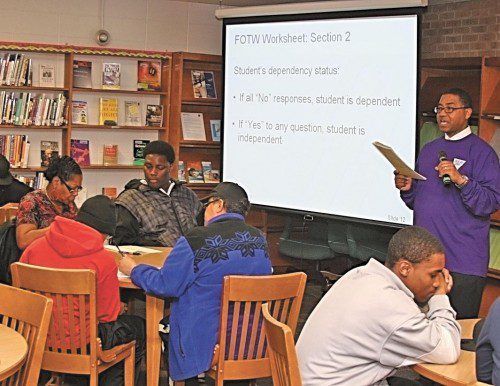 Helping students reach goals Rodney Nichols (standing) gives instructions to parents and students at Arlington High School on College Goal Sunday, a day when volunteers at various high schools help students prepare for higher education. 