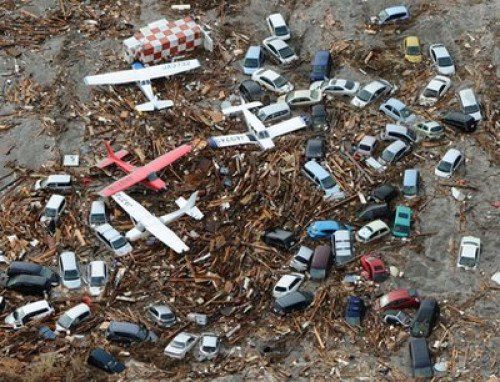 Light planes and vehicles sit among the debris after they were swept by a tsumani that struck Sendai airport in northern Japan on Friday March 11, 2022. A magnitude 8.9 earthquake slammed Japan's eastern coast Friday, unleashing a 13-foot (4-meter) tsunami that swept boats, cars, buildings and tons of debris miles inland.  (AP Photo/Kyodo News) JAPAN OUT, MANDATORY CREDIT, FOR COMMERCIAL USE ONLY IN NORTH AMERICA