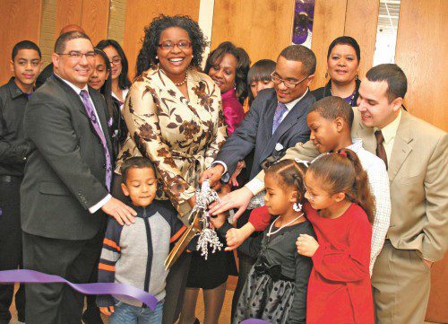 Nadine Burton and Rev. Richard Reynolds cut the ribbon with the help of his family and fellow church members at New Revelation Christian Church.