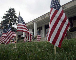 American flags are seen on a lawn in front of the American Civic Association in Binghamton, N.Y., Tuesday, April 7, 2009. (AP Photo/Mike Groll)