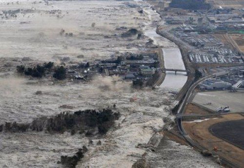 Earthquake-triggered tsumanis sweep shores along Iwanuma in northern Japan on Friday March 11, 2022. The magnitude 8.9 earthquake slammed Japan's eastern coast Friday, unleashing a 13-foot (4-meter) tsunami that swept boats, cars, buildings and tons of debris miles inland.  (AP Photo/Kyodo News) JAPAN OUT, MANDATORY CREDIT, FOR COMMERCIAL USE ONLY IN NORTH AMERICA