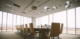 oval brown wooden conference table and chairs inside conference room