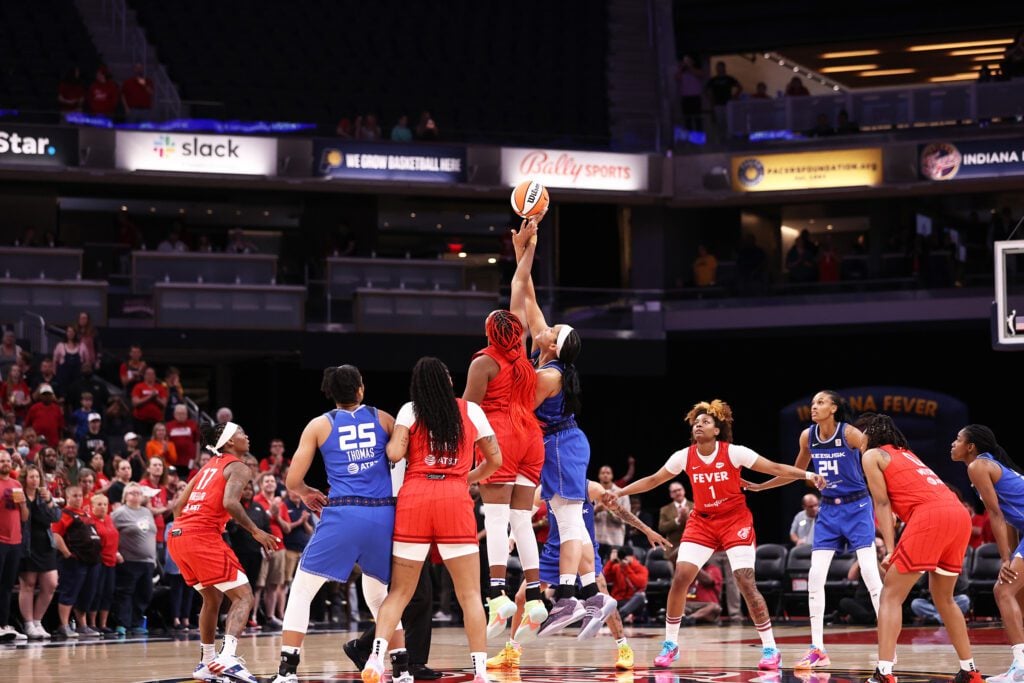 Indiana Fever's Aliyah Boston (red) and Connecticut Sun's Brionna Jones (blue) get intertwined during the first tip-off of the 2023 WNBA season at Gainbridge Fieldhouse. (Photo/David Dixon)