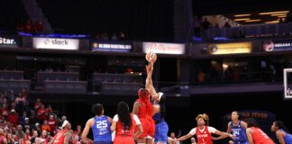 Indiana Fever's Aliyah Boston (red) and Connecticut Sun's Brionna Jones (blue) get intertwined during the first tip-off of the 2023 WNBA season at Gainbridge Fieldhouse. (Photo/David Dixon)