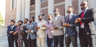 Black men enrolled at Harvard University with arms interlocked in front of Widener Library in Cambridge, Massachusetts. Individuals pictured from left to right: Nasir Stovall, Jordan Biggers, Taylon Lancaster, Ahmaad Edmund, Kevin Ross, Korde Innis, Kenneth Asher, Michael Bediako, Borniface Kabongo, Chika Okafor. (Photo/Corban Swain)