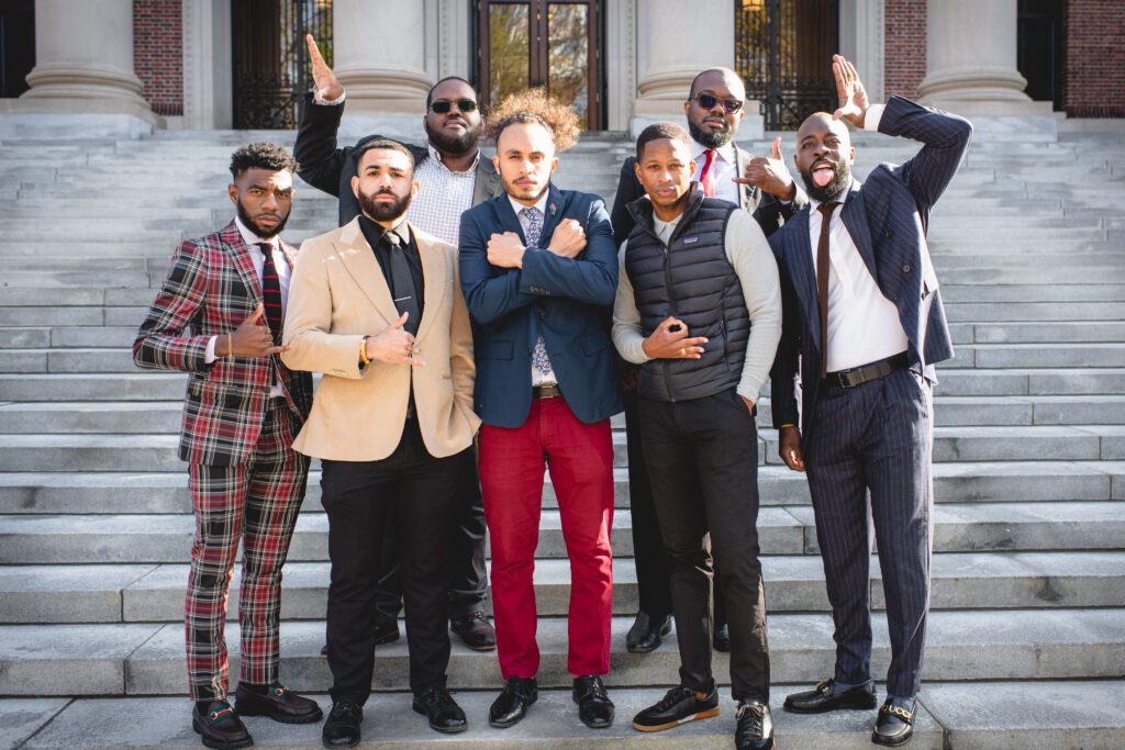 Black men enrolled at Harvard University and members of historically Black fraternities in front of Widener Library in Cambridge, Massachusetts. Individuals pictured from left to right back row: Rakim Williams, Chika Okafor; front row: Taylon Lancaster, Drake Johnson, Aundrey Page, Derwin Sisnett, Terrance Mitchell. (Photo/Corban Swain)