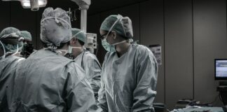 group of surgeons gathered around in an operation room, men's health