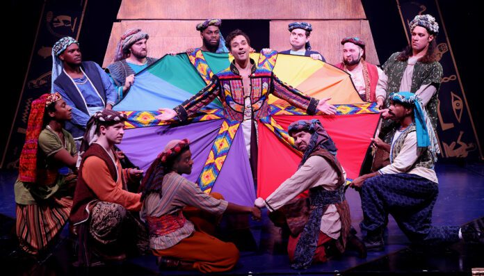 Joseph (TJ Wessel), center, singing about his multicolored coat in Beef & Boards Dinner Theatre's production of Joseph and the Amazing Technicolor Dreamcoat, now on stage through Nov. 19. (Photo provided/Beef and Boards)