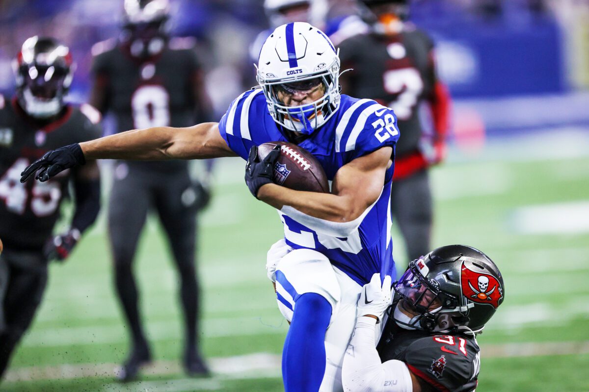 An Indianapolis Colts player escaping a Tampa Bay Buccaneers defender during a game.