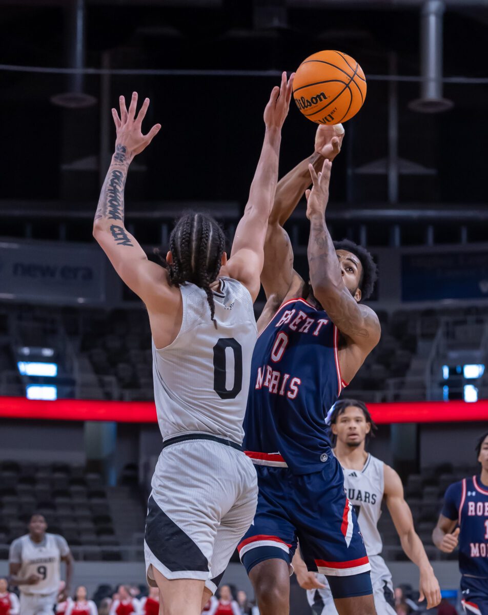 IUPUI basketball player Jlynn Counter (0, Blue) goes up strong against Colonials' Markeese Hastings (0, Gray) during their matchup at Indiana Farmers Coliseum on January 20, 2024. (Photo/Walt Thomas)