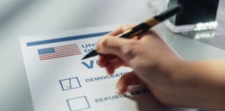 Close Up View on an Anonymous Person Filling Out a Ballot in a Voting Booth on the Day of National Elections in the United States of America. Man or Woman Choosing to Vote for Democratic Party (Photo/Getty Images)