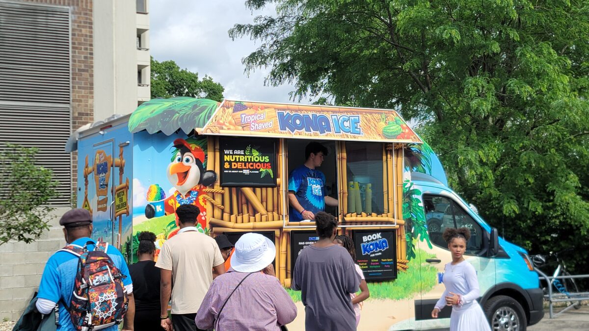 Community members gathering around a vendor at the MLK Community Block Party on May 17 2024 at the MLK Center at 40 W. 40th Street in Indianapolis, IN. (Photo/Noral Parham)