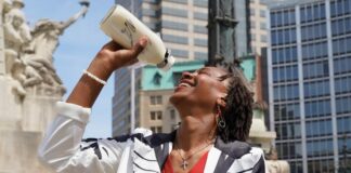 Grand Marshal of the 2024 Indy 500 Parade Tamika Catchings posing with the iconic milk jug, often associated with the Indianapolis 500. (Photo/500 Festival)