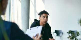 Black teenage boy having counselling with mental health professional during therapy session. (Getty Images)