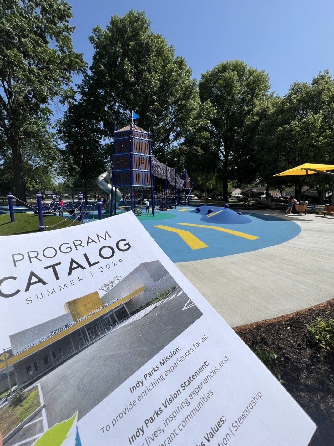 A program catalog displayed in front of a children's playground