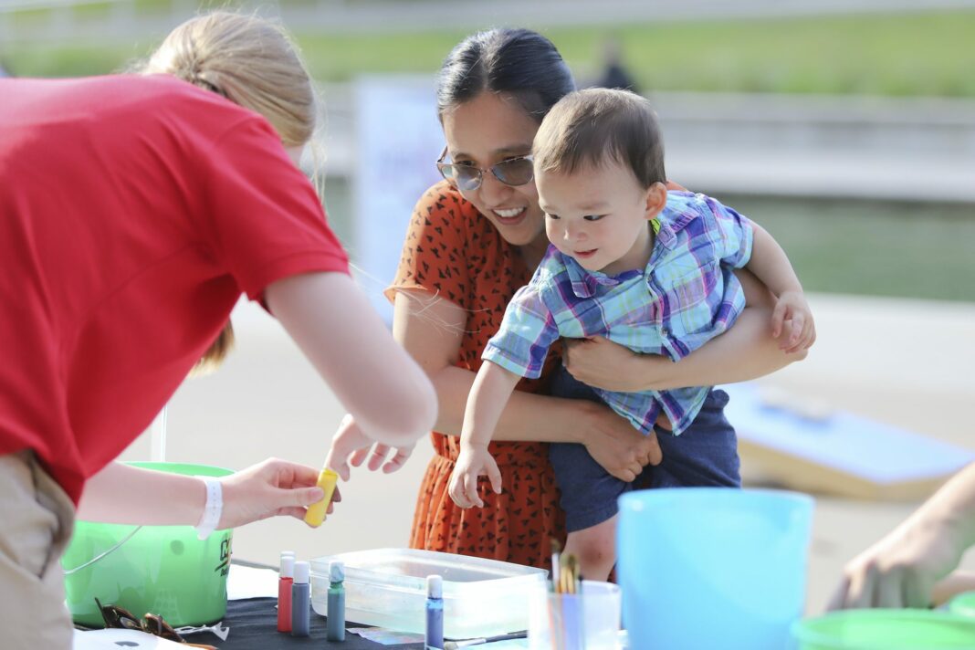 A woman and child play with activities outdoors