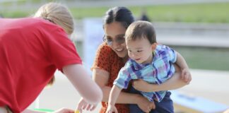 A woman and child play with activities outdoors