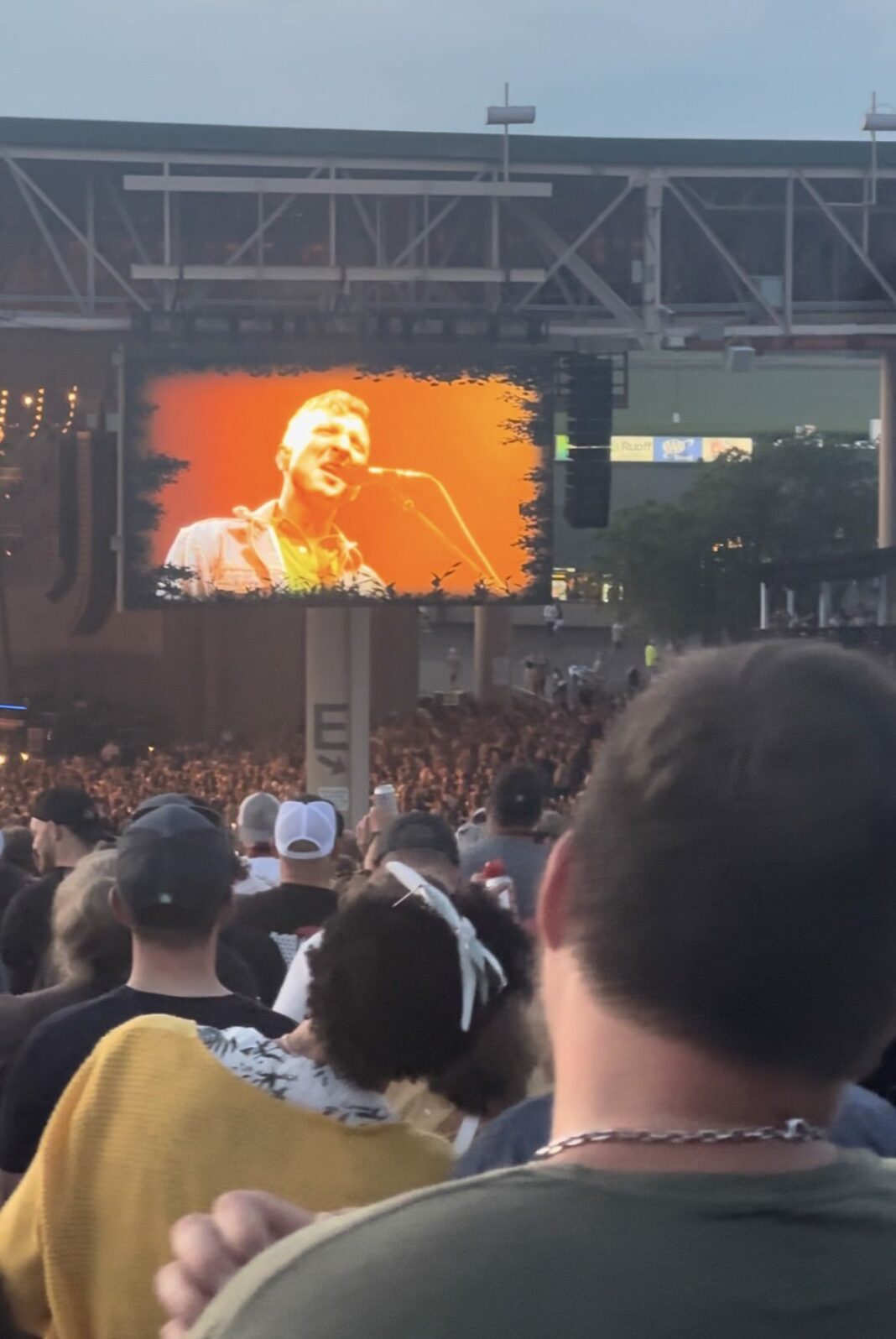 artist sings on screen at country concert