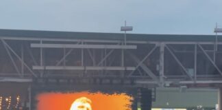 artist sings on screen at country concert