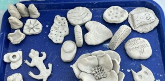 A bunch of clay ceramic objects sit on a blue tray
