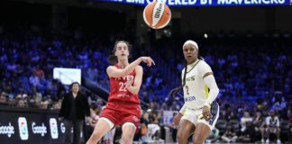 WNBA player passing basketball.