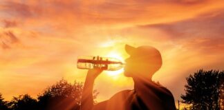 Silhouette of a man drinking water during heat wave