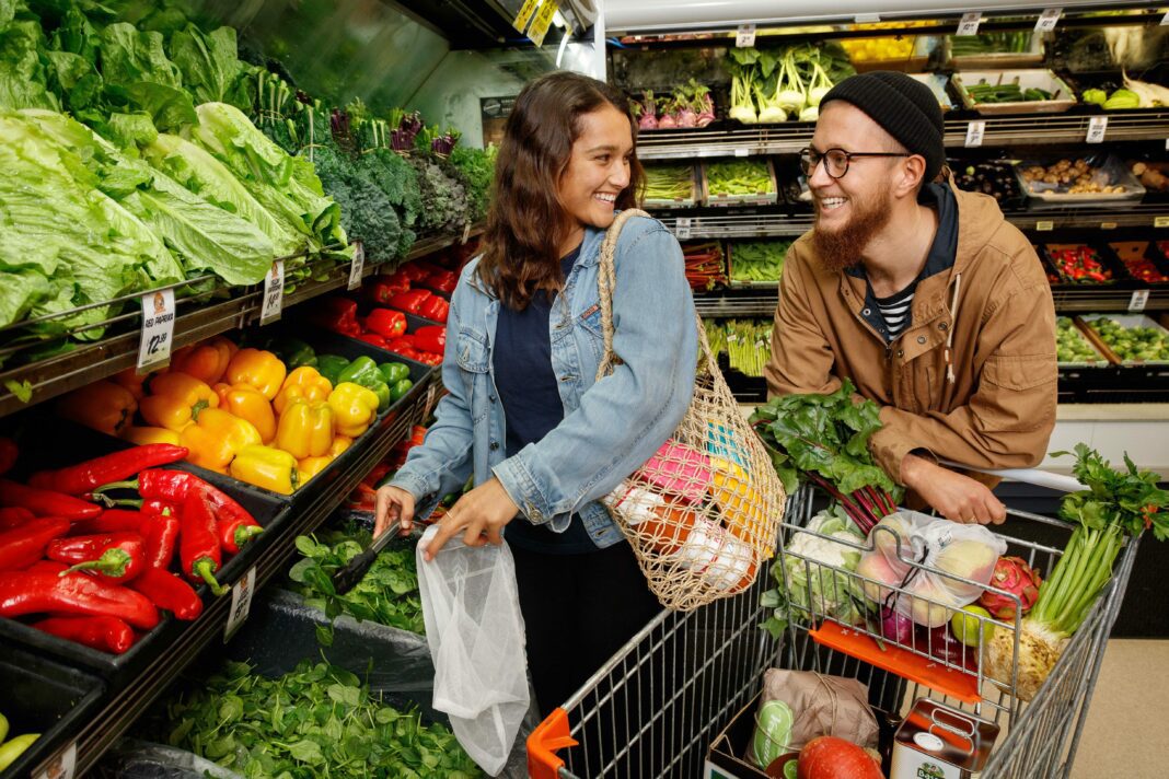 Man and woman shop for fresh fruit and vegetables