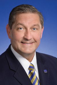 White man in suit with a blue background