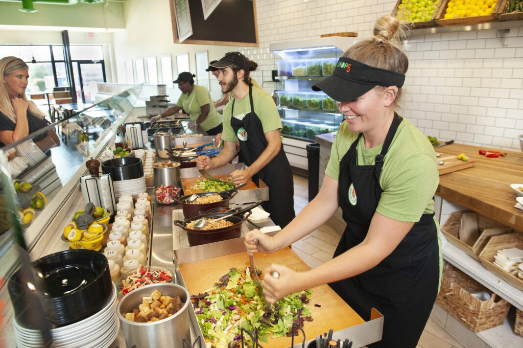 workers making food at a salad restaurant