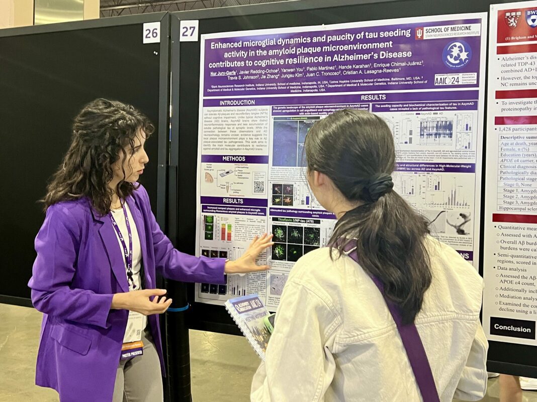 woman presents poster at conference