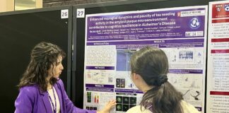 woman presents poster at conference