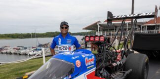 Antron Brown next to his race car.