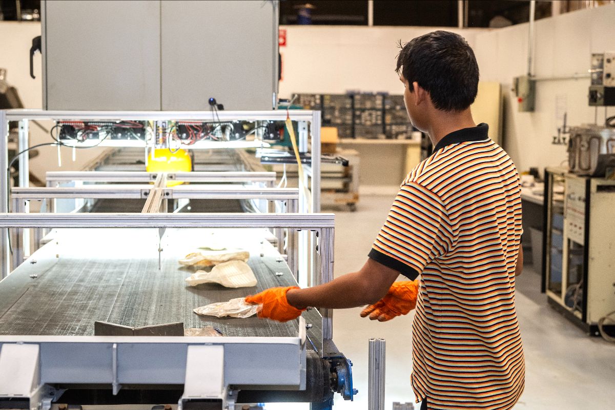 man send plastic bottle on conveyer belt