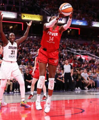 Temi Fagbenle corralling a rebound during a WNBA game.