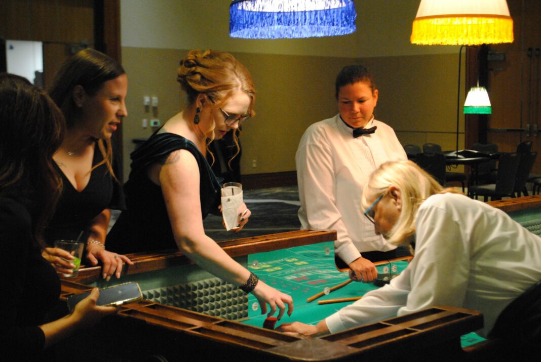 people gather around poker table at event