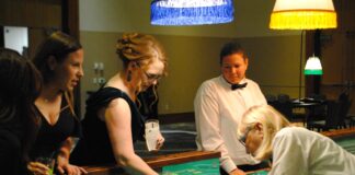 people gather around poker table at event