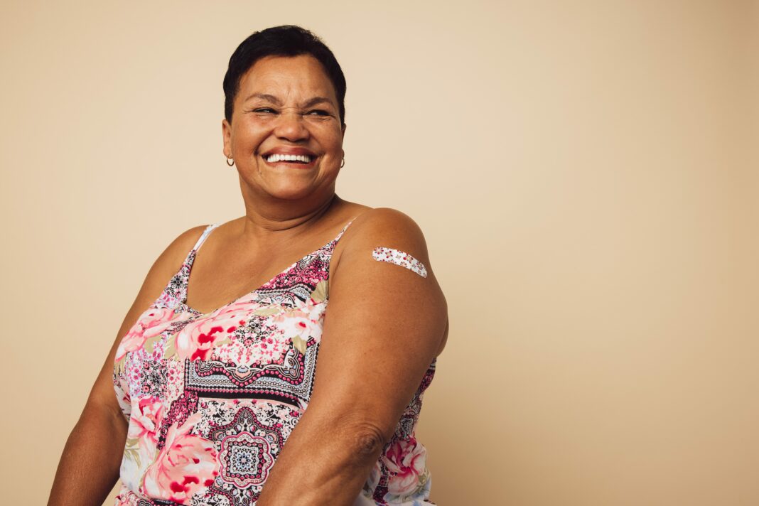 woman smiles with bandage after receiving a vaccination