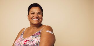 woman smiles with bandage after receiving a vaccination
