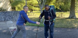 staffer helps refugee prepare for hiking