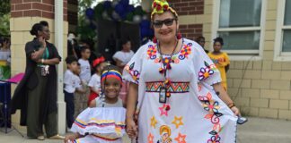 young student from Global Prep Academy stands with her teacher in cultural garb