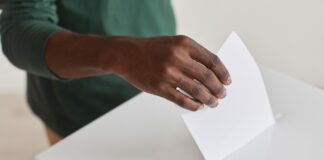 Close-up of African man holding ballot and giving his voice during voting