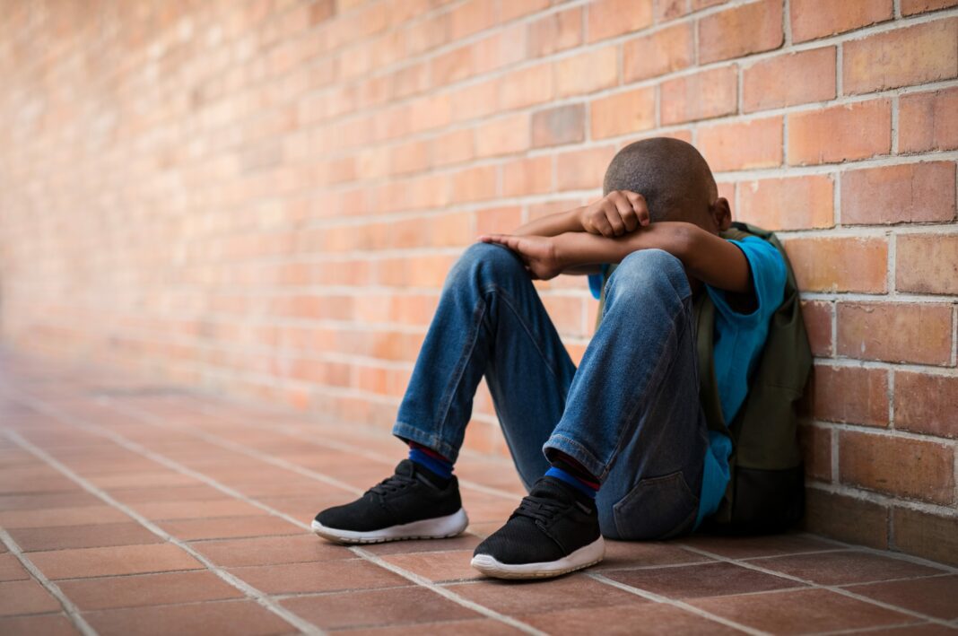 boy sitting alone after being bullied