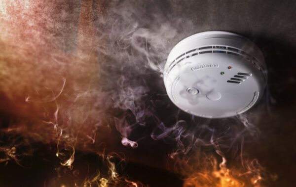 Smoke detector and fire alarm in action background with copy space