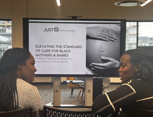 two women chat in front of presentation screen
