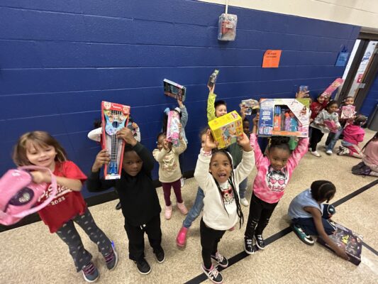 Kids holding up toys