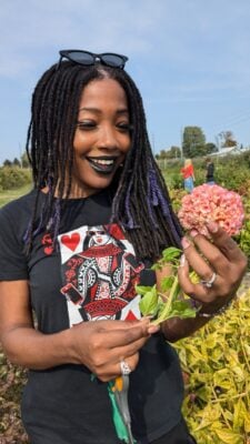 woman smiling at flower