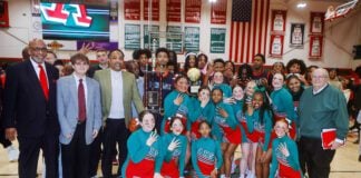 a group photo of basketball players, coaches and staff at Anderson High School after winning its fourth consectutive championship.