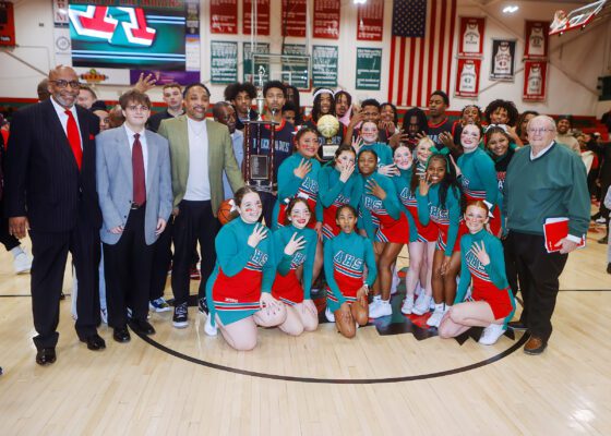 a group photo of basketball players, coaches and staff at Anderson High School after winning its fourth consectutive championship.