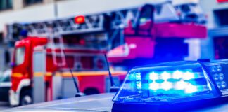 Blue Flash Light Of Police Car Against Red Fire Truck